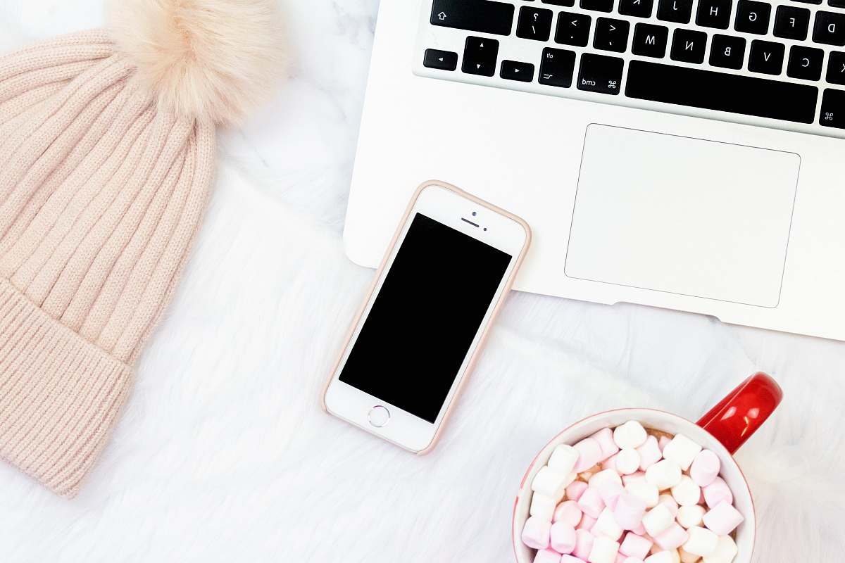cell phone flat-lay photography of gold iPhone 5s beside bobble hat and MacBook mobile phone